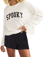 Z Supply Spooky Sweater in cream/sandstone knit with bold black collegiate lettering, model wearing with polka dot shorts, front view