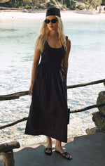 Z SUPPLY Johanna Midi Dress in dark black on a blonde model at a Mediterranean beach, featuring scoop neck and full skirt