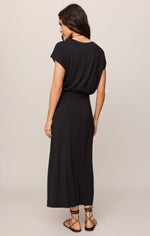 Z SUPPLY Anika Midi Dress in Black — back view on model, short cap sleeves, blouson top, ankle-length skirt, worn with lace-up sandals.