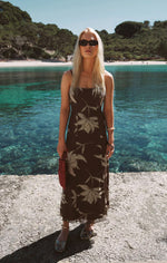 Z SUPPLY Charisma Floral Midi Dress in dark chocolate with leaf print, worn by blonde model at a coastal beach location