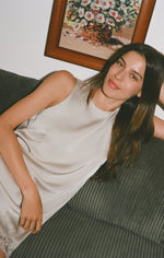 Z SUPPLY Meadow Muse Lace Mini Dress in Frosted Pearl satin-finish fabric, model lounging on grey couch, front view