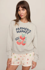 Z SUPPLY Home Grown Sweatshirt in Feather Grey with Farmer's Market tomato graphic, worn by model with patterned shorts, front view.