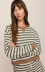 Z Supply Low Key Stripe Sweatshirt in Monstera, olive green and cream horizontal stripes with tan trim, worn by model with arms crossed