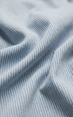 Close-up of Z SUPPLY Carpenter Pant Seaboard Stripe fabric, showing light blue and white diagonal stripe denim weave texture