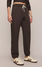 Z SUPPLY Uptown Jogger in Cocoa Bean dark brown fleece sweatpants with cream drawstring, worn by model with Adidas sneakers