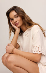 Z SUPPLY Daya Embroidered Top in White worn by model, featuring floral eyelet cutwork details and scalloped short sleeves