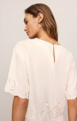 Z SUPPLY Daya Embroidered Top in White, back view on model showing eyelet floral embroidery at hem and sleeves with keyhole closure
