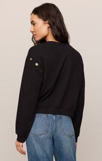 Z SUPPLY Axel Grommet Sweatshirt in black, back view on model, showing gold grommet hardware at shoulder seam, worn with blue jeans.