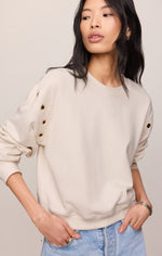 Z SUPPLY Axel Grommet Sweatshirt in Sandstone, front view on model, featuring gold grommet details along shoulder seam and crew neck.