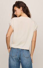 Z SUPPLY Marika Lace Trim Muscle Tee in Cloud — back view on model, cream tee with delicate lace sleeve trim, paired with blue jeans.