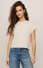 Z SUPPLY Marika Lace Trim Muscle Tee in Cloud — cream cropped tee with lace sleeve trim, worn with blue jeans, front view on model.