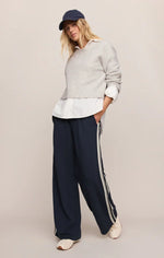 Z SUPPLY Stand In Sweater in Feather Grey worn by model over white shirt with navy track pants and cap, front view