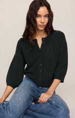 Z SUPPLY Valor Cardigan in Emerald Cove, a dark green knit with button front, split neckline, and 3/4 puff sleeves, worn by a model with jeans.