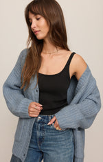 Z SUPPLY Whitmore Cardigan in Mineral Blue worn open over a black tank top with jeans, featuring chunky ribbed knit and button front