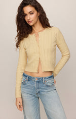 Z SUPPLY Cera Long Sleeve Cardigan in Lemon Chiffon — cable-knit cropped cardigan with button front, worn open over jeans by a model