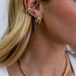 Sahira Kendall Two Tone Pave Hoop earrings styled with gold ear cuff on blonde model, also wearing gold herringbone necklace