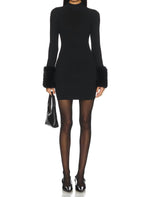 Steve Madden Riello Dress in black — fitted turtleneck mini dress with long sleeves and fluffy faux fur cuffs, worn with sheer tights
