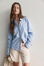 Free People Benny Slim Oxford in Blue Combo — model wearing light blue button-down shirt with cream denim shorts, front view