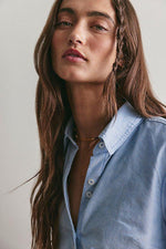 Free People Benny Slim Oxford in Blue Combo, close-up model shot showing light blue button-down shirt with pointed collar and white buttons
