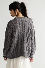Free People Opal Cardigan in Steel Grey, back view on model, chunky cable-knit pattern with balloon sleeves