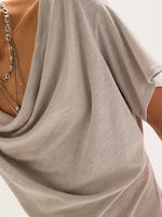 Free People Waterfall Cowl in Chateau Grey, close-up of draped cowl neckline with layered silver chain necklaces and short sleeves.