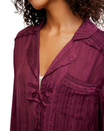 Free People Let's Sleep In Set close-up detail showing deep burgundy satin jacquard fabric with tie closure and notch collar on model