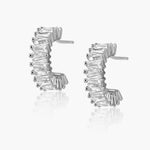 Sahira Dakota Mini Hoops in silver, featuring baguette-cut clear crystals set in C-shaped half-hoop studs, pair shown on white background.