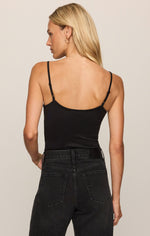 Z Supply Luxe Smooth Essential Tank in black, back view on model, featuring thin adjustable straps and a low back, paired with dark wash jeans.