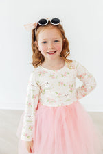 Mila Spring Kittens L/S Tutu Dress — cream floral kitten-print long-sleeve bodice with pink tulle skirt, worn by a smiling girl.