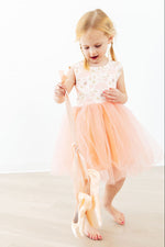 Young girl wearing Mila Ballet Tank Tutu Dress in soft blush pink with floral bodice and flowing tulle skirt