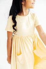 Mila & Rose S/S Pocket Twirl Dress in Butter Yellow - model wearing short sleeve dress with gathered skirt and side pockets