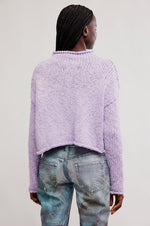 Opal Sweater in Purple Satin by Tempemail.Pdf, back view on model, chunky knit lavender cropped pullover with raw edges, worn with distressed jeans