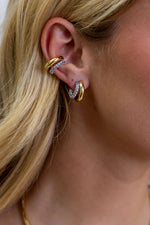 Sahira Kendall Two Tone Pave Hoop earrings styled on model's ear with gold hoop and crystal-encrusted silver pave band, paired with matching ear cuff.
