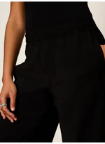 Sanctuary Micro Balloon Pant in black, close-up detail view showing high waist, pleating, and clean fabric on model