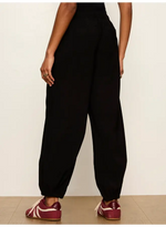 Sanctuary Micro Balloon Pant in black, back view on model, relaxed balloon silhouette with elasticated cuffs, worn with burgundy sneakers