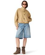 Steve Madden Fayden Jacket in tan/khaki with button front and stand collar, worn by model with denim shorts and wedge sneakers