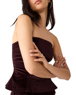 Steve Madden Dawnette Top in Deep Fig — strapless velvet peplum bustier top, model wearing with arms crossed, side angle view