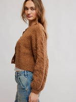 Free People Thistle Cardi in Macadamia, a cropped bouclé knit cardigan in warm camel brown, side view on model with jeans.