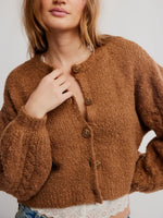 Free People Thistle Cardi in Macadamia, a warm brown bouclé button-front cropped cardigan with balloon sleeves, worn by a model.