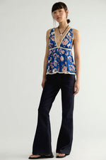 Free People Rome Printed Tank in Navy Combo, blue floral sleeveless peplum top with lace trim, worn with dark flare jeans, front view on model.