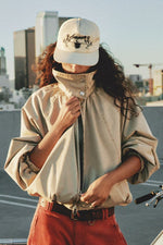 Free People Chelsea Jacket in Oatmeal worn by model, oversized tan zip-up with balloon sleeves, paired with rust trousers