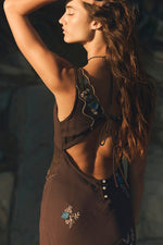 Free People Meet Again Midi dress in brown with embroidered floral details, worn by model with arms raised in golden light