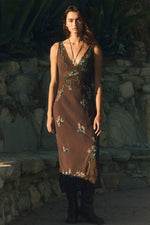 Free People Meet Again Midi dress in brown with floral embroidery, worn by model against stone wall backdrop
