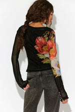 Free People Lilly Printed Longsleeve in Black Combo, back view on model, sheer mesh sleeves with large floral print