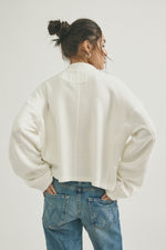 Free People Celeste Quarterzip in Clean Ivory, back view on model, ribbed texture, oversized fit, paired with blue jeans.