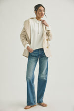 Free People Celeste Quarterzip in Clean Ivory worn by model with beige blazer and wide-leg jeans, front view showing half-zip neckline and ribbed texture.
