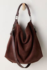 Free People Suzie Suede Slouch Tote in Espresso, a rich brown slouchy hobo bag with leather handles, hanging on a wooden wall hook.