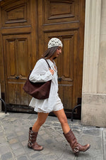 Free People Suzie Suede Slouch Tote in Espresso worn by model in white outfit and brown boots on cobblestone street