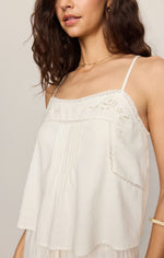 Z SUPPLY Lille Embroidered Woven Tank in white, close-up of model wearing spaghetti-strap top with floral eyelet embroidery and lace trim details