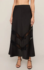 Z Supply Kori Lace Inset Skirt in black satin with chevron lace panels, front view on model with strappy heels
